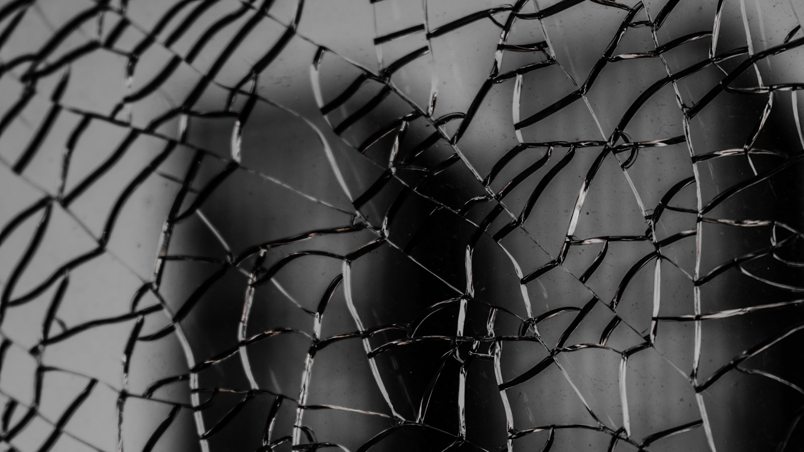 A pane of glass shattered into a web of cracks