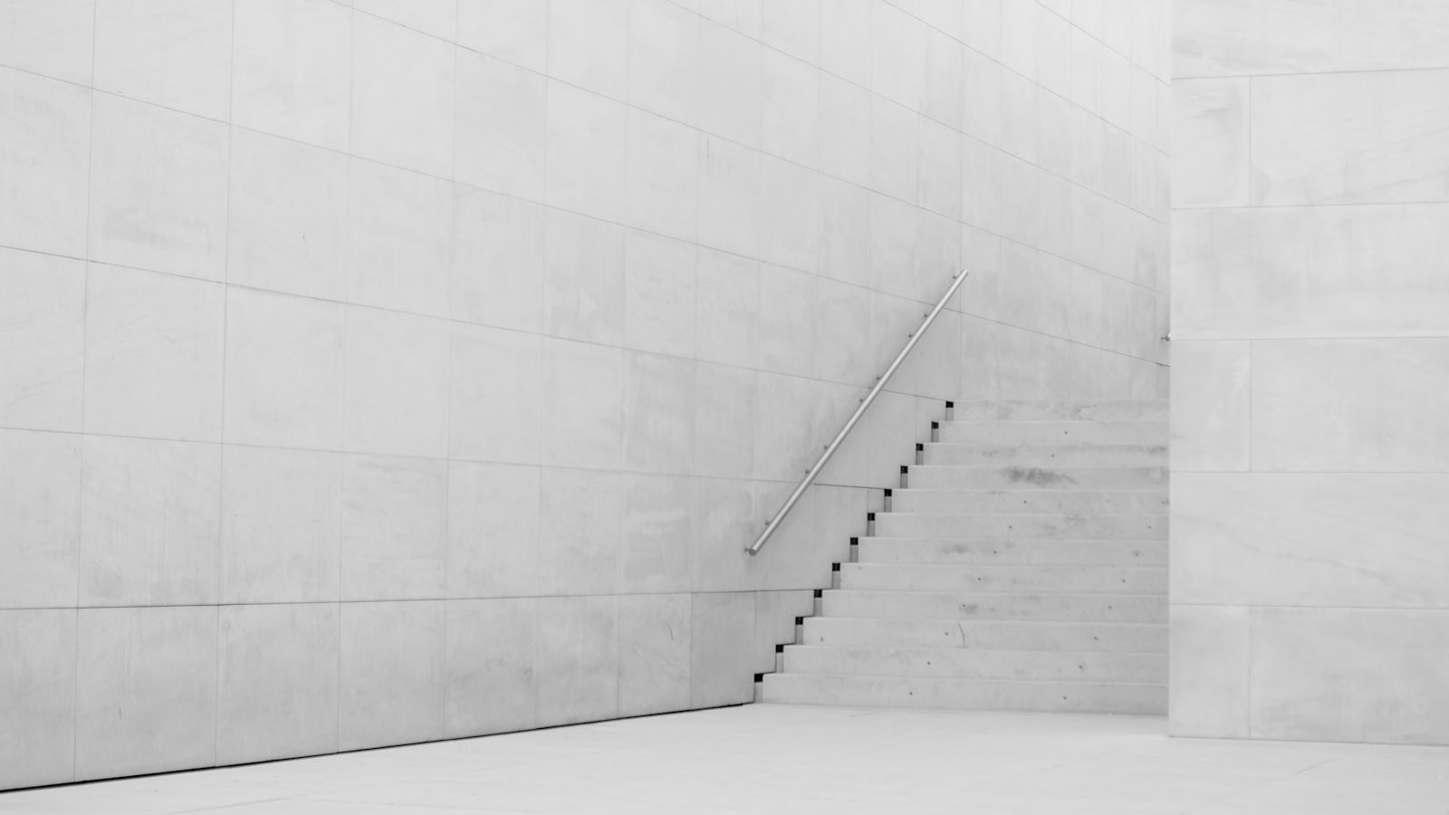 A minimal concrete staircase against a bare wall